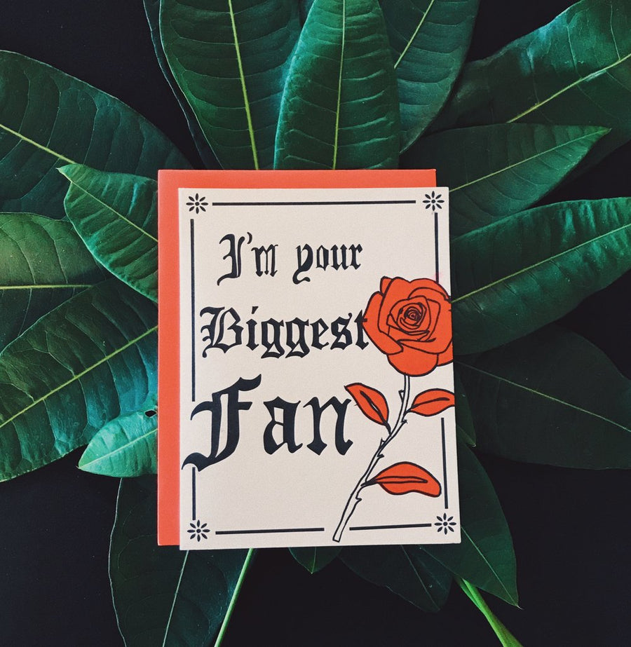 Trendy greeting card I'm Your Biggest Fan Old English Hand Illustrated with a Rose and laid on top of a bundle of forest green leaves. 